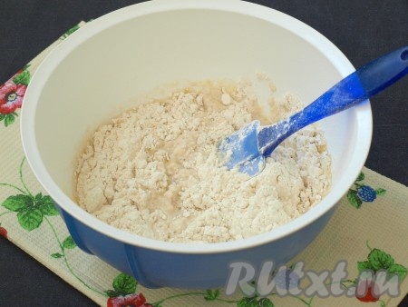 Затем добавить в смесь дрожжей и масла 300-320 грамм муки и перемешать лопаткой.
