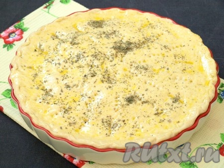 Из меньшей части раскатать лепёшку по диаметру формы, накрыть начинку и закрепить тесто по окружности, скрепляя нижнюю и верхнюю лепёшки. Смазать верх пирога взбитым яйцом, наколоть вилкой для выхода пара и, по желанию, посыпать прованскими травами.
