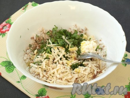 В получившуюся начинку из риса и рыбных консервов добавить мелко нарезанную зелень, натертый сыр, соль, перец и сметану, всё хорошо перемешать. Яйцо взболтать в чашке, немного оставить для смазывания пирога, а остальное вылить в начинку, ещё раз перемешать.