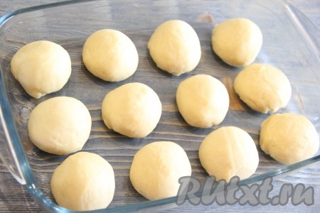 Готовое тесто обмять, затем разделить на небольшие кусочки (я разделила на 12 кусочков). Из каждого кусочка теста сформировать круглую булочку. Форму для выпечки смазать растительным маслом, выложить в форму круглые булочки, накрыть пищевой плёнкой и оставить на 1 час в тепле. Подошедшие булочки отправить в разогретую духовку и выпекать,&nbsp;примерно, 40 минут при температуре 200 градусов. Для приготовления сахарной заливки соединить молоко, растопленное сливочное масло, сахарную пудру и ванильный сахар, перемешать. За 10 минут до окончания выпечки смазать булочки сахарной заливкой (я покрывала булочки с помощью силиконовой кисточки) и снова поставить в духовку. 