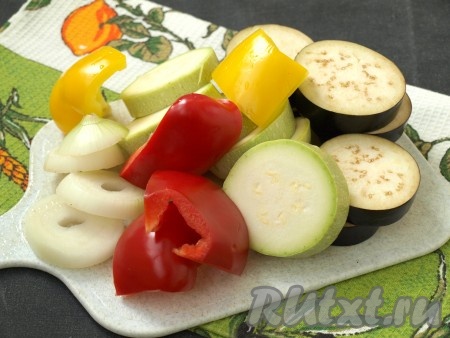 Овощи вымыть. Перец очистить от семян и нарезать удобными кусочками, кабачки и баклажаны нарезать кружочками толщиной 7-8 мм, лук - кольцами такой же толщины.
