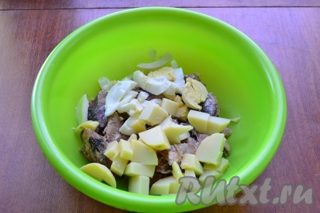 Картошку и яйцо очистить, нарезать крупно и добавить в миску с рыбными консервами.