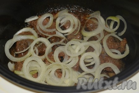 На мясо выкладываем часть колец лука.
