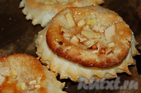 После выпечки всю поверхность горячих пирожных из слоеного теста с миндальным кремом и яблоками сразу смазываем любым прозрачным джемом или сиропом из варенья.