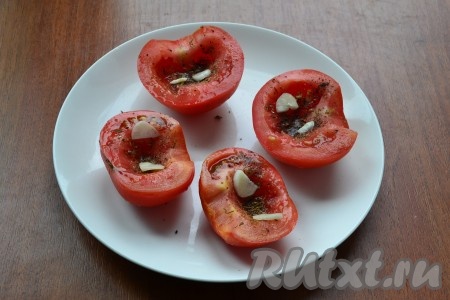 Помидоры посолить, поперчить, посыпать хмели-сунели и ароматными травами, посыпать резаным чесноком.