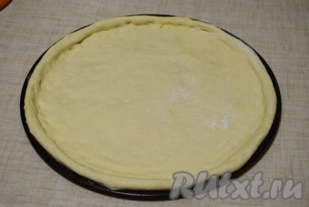 Припылив руки мукой, равномерно растянуть тесто по периметру всей формы, формируя бортики.
