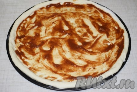 Смазать тесто томатным соусом.
