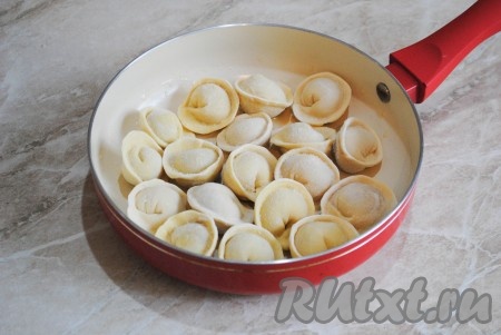 Разогреть сковороду и выложить в один слой замороженные пельмени.&nbsp;
