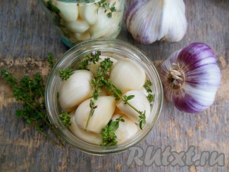 Затем положите очищенные зубчики чеснока, между зубчиками, по желанию, выложите небольшие веточки лимонного чабреца. Вместо чабреца можно взять пару веточек розмарина или использовать сухие прованские травы (по 1 чайной ложке на одну баночку). 