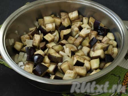 Теперь можно приступать к жарке. С баклажанов необходимо слить воду и откинуть их на полотенце для удаления лишней влаги. Разогреть в сковороде подсолнечное масло, я наливаю совсем немного (около 40 мл). Выложить в сковороду лук, минуту обжарить на среднем огне и добавить баклажаны с чесноком. Жарить ещё 2 минуты, иногда помешивая.
