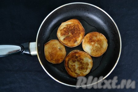 Хорошо разогреть сковороду и влить растительное масло. Через минуту выложить баклажаны. Постепенно обжарить на среднем огне все кружочки баклажанов, выкладывая их в один слой, до золотистой корочки (с каждой стороны по 1 минуте).