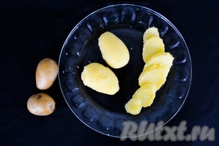 Картофель отварить в мундире: для этого необходимо вымытый неочищенный картофель выложить в кастрюлю, залить холодной водой, добавить&nbsp;немного соли и поставить на огонь. После закипания снизить огонь к минимуму и продолжить варить до готовности. Время варки будет зависеть от размера картошки и её сорта. Картофель должен стать мягким, но не разваренным. После того как он будет готов, слить воду, а картофель остудить. Снять кожуру и нарезать кружочками толщиной 5 мм.
