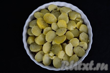 Выложить кружочки картофеля поверх баклажанов, немного посолить и приправить прованскими травами.
