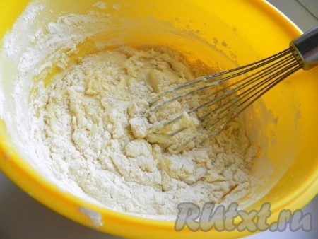 В тесто всыпать разрыхлитель и 200 грамм просеянной муки, перемешать тесто до однородности.