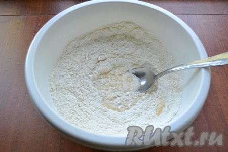 Муку просеять, добавить соду. Постепенно вливая молочную смесь в смесь муки и соды, замесить тесто.
