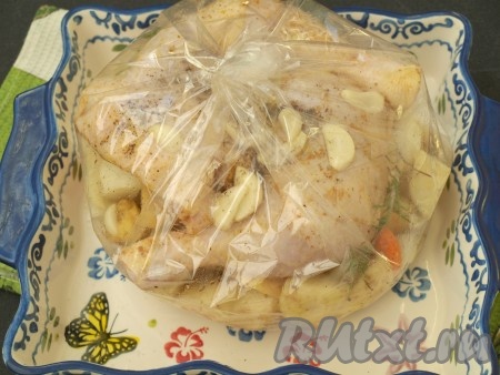 Окорочка поместить в рукав сверху овощей, пластинками нарезать чеснок, добавить веточки розмарина. Рукав завязать с другой стороны и встряхнуть, чтобы масло равномерно распределилось в пакете. Окорочка должны остаться сверху, чтобы на них появилась румяная корочка.