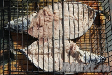 Подготовленную замаринованную скумбрию выложить на решётку в развёрнутом виде и хорошо прижать второй половинкой решётки. В мангале подготовить угли, они должны быть хорошо раскалёнными, но прямого огня быть не должно. Поместить решётку со скумбрией на подготовленный мангал. Запекать скумбрию минут 15, периодически переворачивая решётку. Продолжительность приготовления зависит от жара углей и величины рыбы.