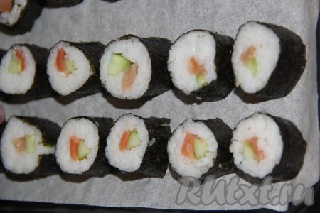 Нарезать рулет на 8 кусочков (использовать хорошо заточенный нож, чтобы не деформировать роллы). Противень для запекания застелить пергаментом. Выложить роллы на противень. Из указанного количества ингредиентов в итоге получается 40 роллов.