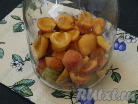 В чистую простерилизованную банку сложить сливы, затем добавить абрикосы.
