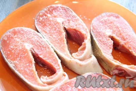  Слегка посолить стейки с двух сторон, затем полить лимонным соком с двух сторон.