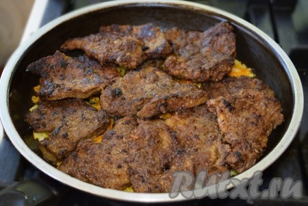 Влить в овощи 3 столовые ложки воды и сверху выложить кусочки говяжьей печени.
