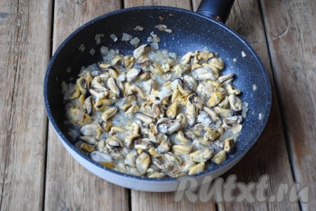 Обжарить мидии с луком в течение 1-2 минут, затем посолить и поперчить по вкусу. Добавить выдавленный через пресс чеснок.