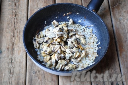 К обжаренному луку добавить мидии. Если мидии свежие - их нужно промыть. Если же Вы будете готовить замороженные мидии, то их нужно разморозить при комнатной температуре, лишнюю жидкость слить и промыть.