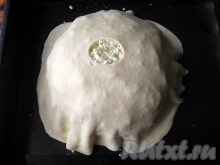 Затем оставшееся дрожжевое тесто (небольшой кусочек теста оставьте для украшения курника) раскатать в большой тонкий круг. В центре круга сделать небольшое отверстие и накрыть этим тестом пирамиду из начинок и блинов, соединить края этого теста с краями нижнего круга теста. По возможности красиво подвернуть.
