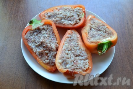 Нафаршировать половинки перца подготовленным фаршем.