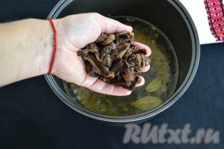 Грибы, замоченные в воде, слегка отжать от воды и выложить в чашу мультиварки, закрыть крышку мультиварки.
