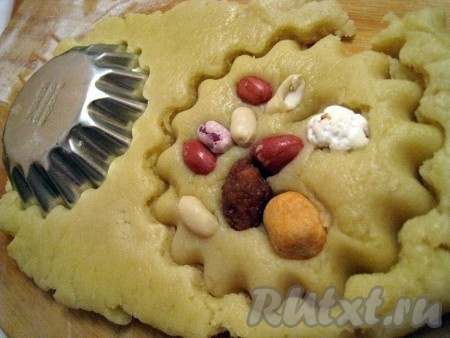 Тесто раскатать примерно толщиной 1 см, вдавить орехи и нарезать коржики формочками (например, металлическими для кексов).