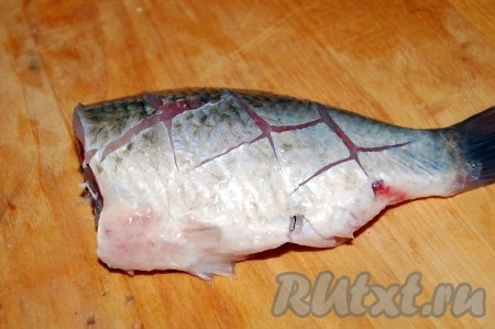 Сделать крестообразные надрезы с каждой стороны (как на фото). Таким образом перерубим мелкие косточки, чтобы удобно было есть рыбу.