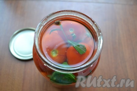 В воду добавить соль и сахар, поставить на огонь и кипятить 2-3 минуты (с момента закипания). Далее влить уксус и залить горячим маринадом помидоры в банках.
