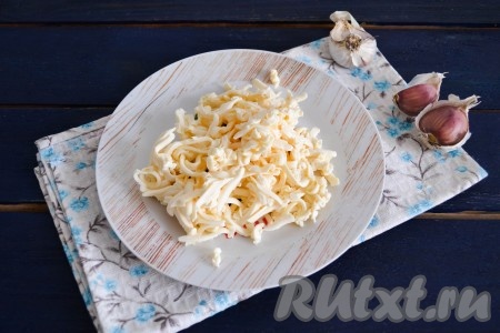 Для приготовления начинки к плавленому сыру, натертому на крупной терке, добавить чеснок, пропущенный через пресс.