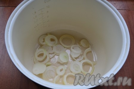 В чашу мультиварки влить растительное масло, выложить очищенный репчатый лук, нарезанный тонкими кольцами или полукольцами.
