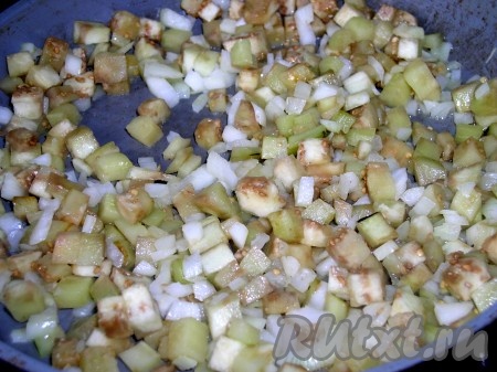 В разогретом растительном масле обжарим сначала на среднем огне баклажаны в течение нескольких минут, помешивая, а затем добавим лук, нарезанную зелень и чеснок, пропущенный через пресс. Обжариваем, помешивая, до золотистости лука, солим и перчим. Обжаренным овощам даём остыть.