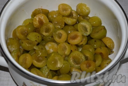 Нарезать сливы на половинки, удаляя косточки, и выложить в кастрюлю.