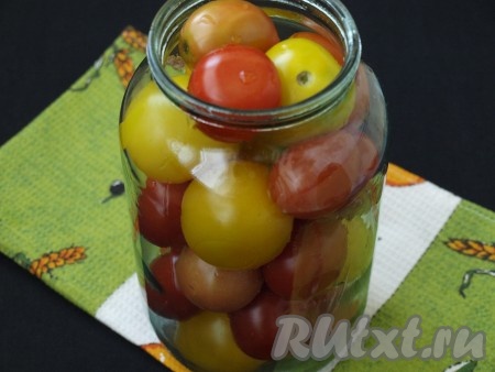 На дно чистой простерилизованной банки выложить листья смородины и малины, лавровые листья и душистый перец. Наполнить банку помидорами.
