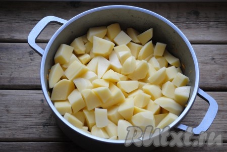 Поверх обжаренных овощей и колбасы выложить кубики картофеля. 