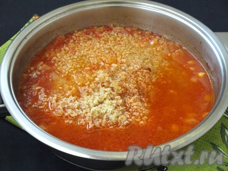 Затем влить в сковороду оставшуюся горячую воду, всыпать промытый булгур, размешать, добавить соль и черный перец, перемешать.
