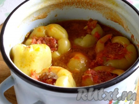 Горячую томатную заливку столовой ложкой залить в каждый нафаршированный перчик. Оставшуюся заливку влить в кастрюлю к перцам на 1/3 или 1/2 от объема посуды. Накрыть крышкой, поставить кастрюлю на сильный огонь и довести до кипения. Затем огонь убавить до среднего, крышку слегка приоткрыть и варить перцы 40 минут.
