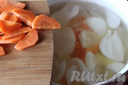 Морковь очистить, нарезать полукольцами и добавить в кастрюлю к луку и картофелю. Затем уменьшить огонь и варить овощи, примерно, 20 минут.
