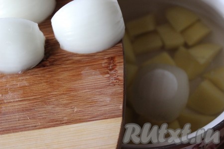 В кастрюлю влить воду, поставить на плиту и довести до кипения, затем опустить в кипящую воду нарезанный картофель и репчатый лук.