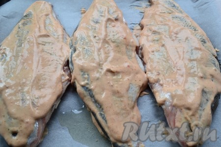 Противень застелить пергаментом и смазать растительным маслом. Каждую рыбку щедро обмазать с двух сторон подготовленным соусом и выложить на застеленный и смазанный маслом противень.