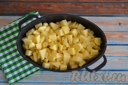 Очищенную картошку нарезать небольшими кубиками, выложить в казан, влить воду, закрыть крышкой и продолжить тушить картофель с овощами и говяжьей печенью на слабом огне 30-40 минут.
