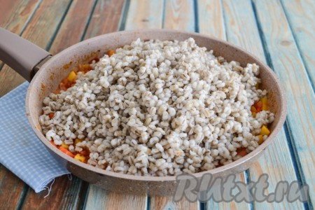 С перловки слить воду, залить 1,5 стаканами чистой холодной воды, поставить на огонь, после закипания огонь уменьшить до минимального и отварить крупу до полной готовности (это займёт 20-25 минут с момента закипания). Выложить перловую крупу в сковороду к овощам и готовой тыкве.
