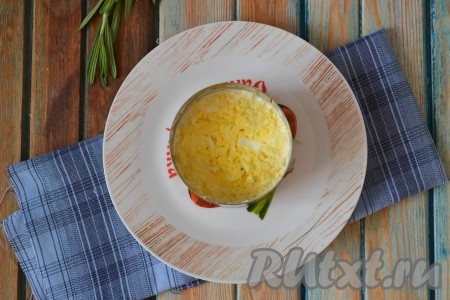 Выкладывается этот салат слоями. На плоскую тарелку поставить формовочное кольцо, выложить половину смеси сыра и чеснока, утрамбовать. Следующим слоем равномерно выложить измельчённые яйца, смешанные с майонезом.