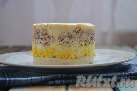 Дальше выложить слой из печени трески, немного утрамбовать, а затем снова идёт слой из сыра и чеснока. Отправить салат в холодильник минимум на 30 минут. Затем аккуратно снять формовочное кольцо.