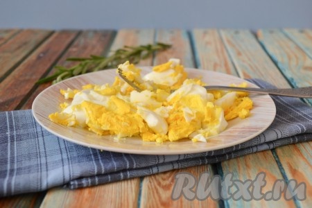 Яйца отварить вкрутую (в течение 10 минут с момента закипания воды), остудить, очистить и также размять вилкой в мелкую крошку (один желток оставить для украшения салата). Затем добавить майонез и тщательно перемешать.