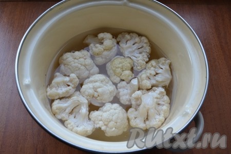 Цветную капусту разобрать на соцветия, выложить в кастрюлю, залить водой, поставить на огонь и, уменьшив огонь после закипания, варить 6-7 минут.